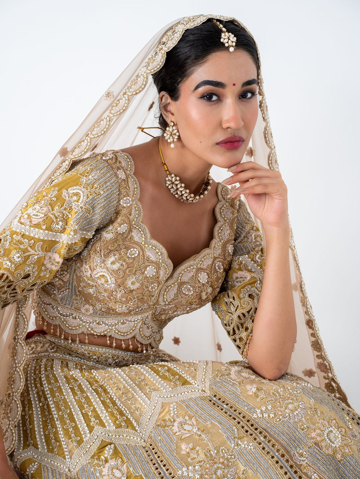 Antique gold cutwork lehenga, seated, full length