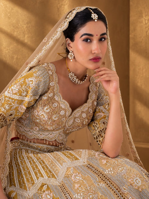 Close-up of the antique gold cutwork lehenga's scalloped sweetheart-neck blouse and zari embroidery