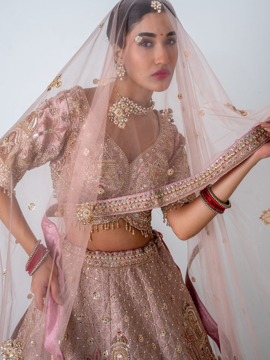Blush pink embroidered lehenga, with the dupatta worn as a veil