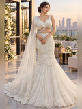 Ivory pearl-embroidered fishtail lehenga with scalloped peplum and trailing sheer dupatta