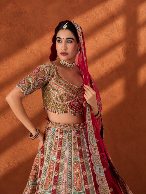 Model in a panelled multicolour hand-embroidered lehenga with resham and bead work and a red dupatta