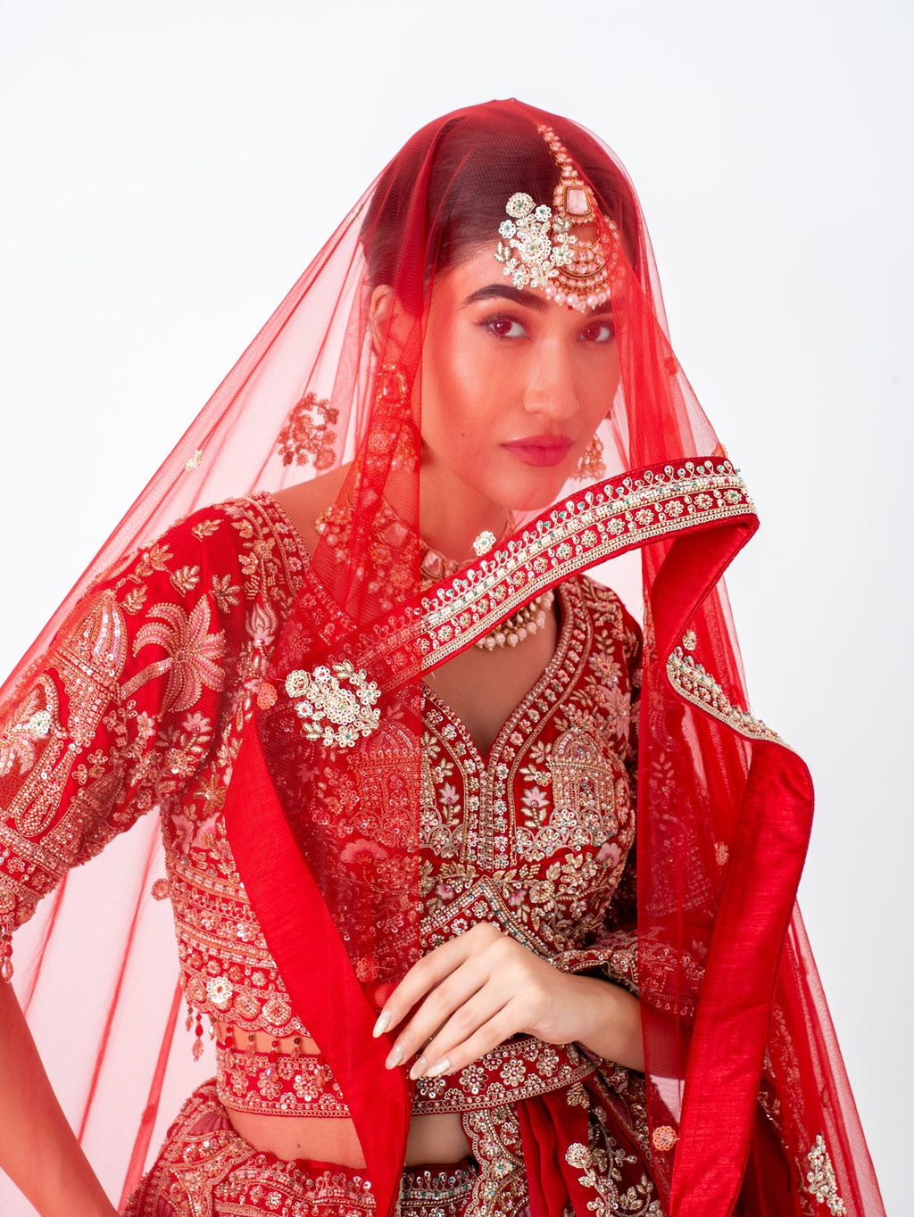 Red velvet bridal lehenga, with the dupatta worn as a veil