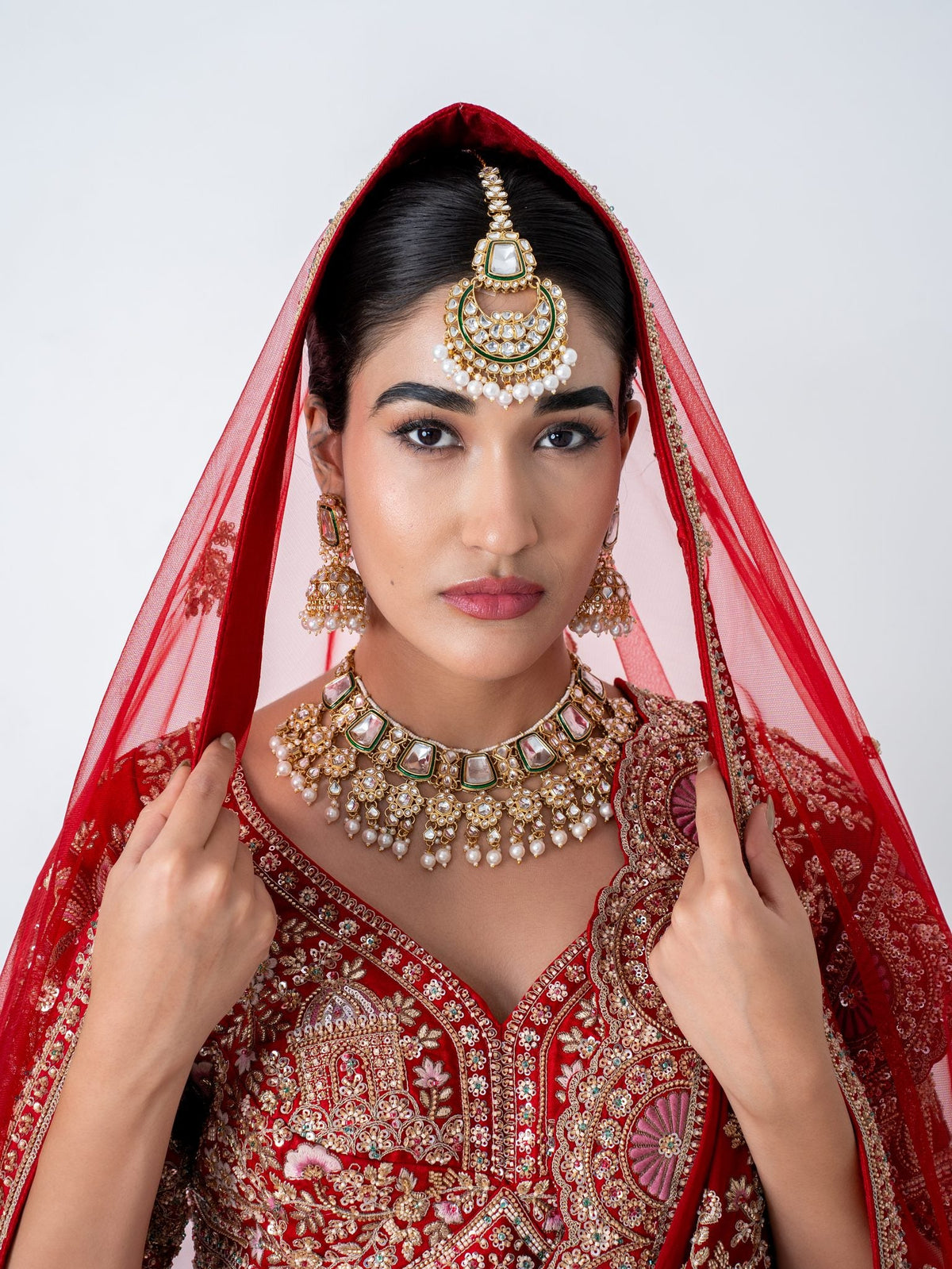 Red velvet bridal lehenga, with the dupatta worn as a veil