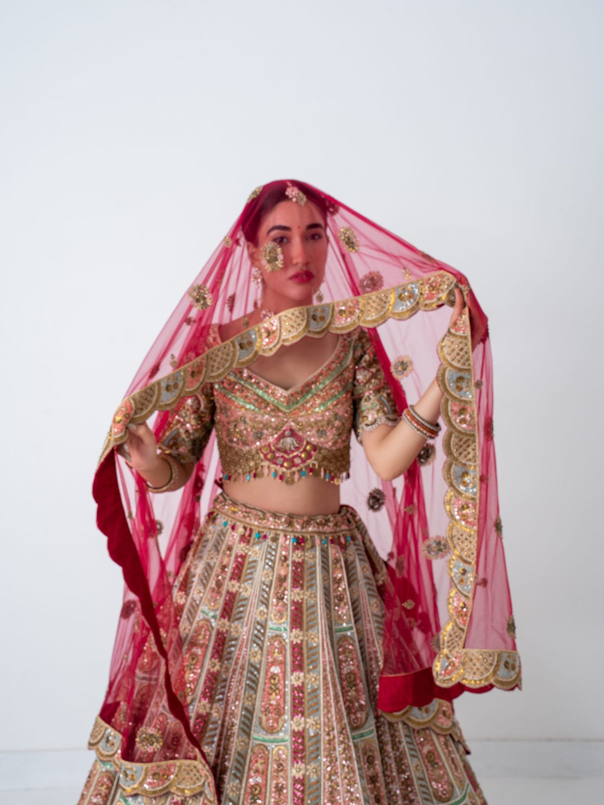 Rose multicolour bridal lehenga, with the dupatta worn as a veil